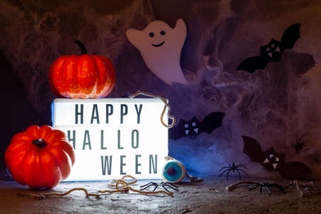 Happy Halloween light box and pumpkins on a spooky background with web, bats, ghost, spiders, horizontalの写真素材