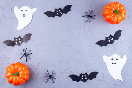 Halloween frame with spiders, ghosts, bats and pumpkin on on gray, horizontal, top view, copy spaceの写真素材