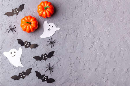 Halloween background with web, spiders, ghosts, bats and pumpkin on gray, horizontal, top view, copy spaceの写真素材