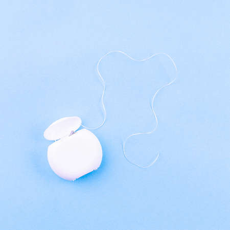 Dental floss on blue background, copy space, square format, top viewの写真素材