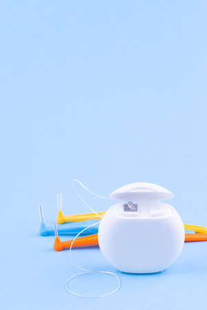 Dental floss and interdental brush angles on blue background, vertical, copy spaceの写真素材