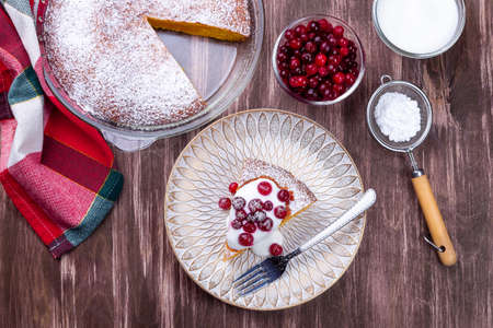 Piece of Swedish saffron Kladdkaka pie with white chocolate, whipping cream and cranberry horizontalの写真素材