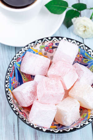 Turkish delight or lokum confection rose and lemon flavored with cup of coffee, vertical, closeupの写真素材