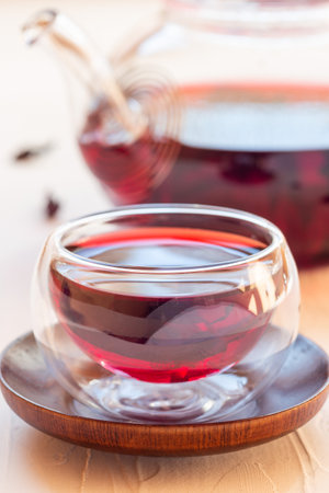 Red tea karkade or hibiscus in glass cup and glass tea pot, vertical, closeupの写真素材