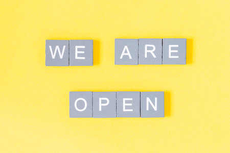 We are open quote, welcome sign for business or caffe, wooden letters on yellow background