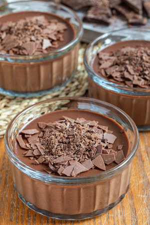 Chocolate dessert Panna Cotta in glass ramekin, wooden background verticalの写真素材