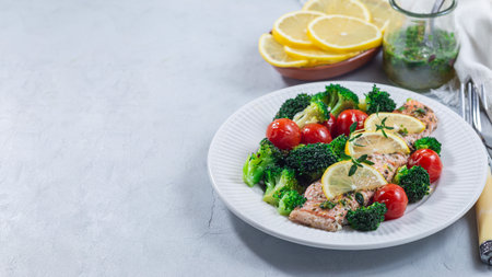 Salmon steak with vegetables, baked salmon fillet with broccoli and tomato, horizontal, copy spaceの写真素材