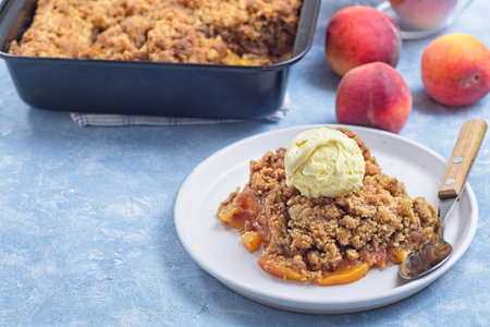 Peach Crisp or cobbler on plate with scoop of vanilla ice cream, horizontal, copy spaceの写真素材