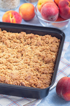 Peach Crisp or cobbler with brown sugar and oat streusel in backing dish, verticalの写真素材