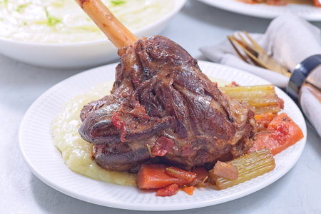 Braised lamb shanks with vegetables served with horseradish and fennel mashed potatoesの写真素材