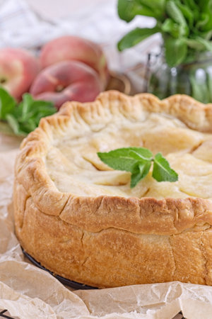 Old fashioned deep dish peach pie cooling on baking rack, verticalの写真素材