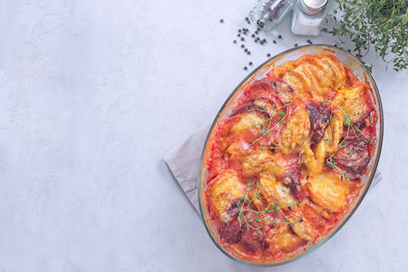 Gratin with sweet potato, parsnips, beet root and melted cheese, horizontal top view, copy spaceの写真素材