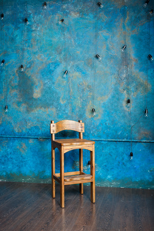 Old wooden chair in grunge room with blue wall. Verticalの写真素材