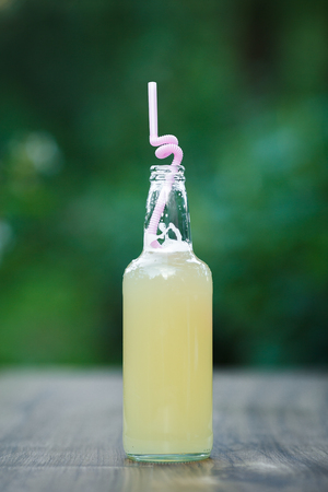 homemade lemonade in glass bottle on bokeh background. Lemon beer.の写真素材