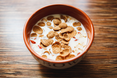 Healthy breakfast - a bowl of corn flakes with dried goji berries, selective focus.