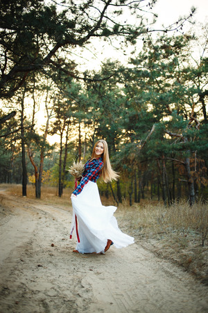 fine young woman wearing a wedding dress with a plaid shirtの写真素材