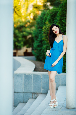 Elegant brunete girl in fluttering blue dress on high heelsの写真素材