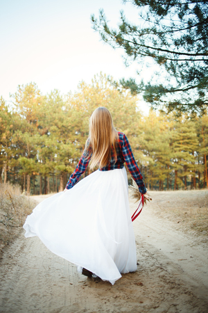 fine young woman wearing a wedding dress with a plaid shirtの写真素材