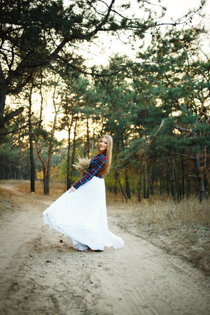 fine young woman wearing a wedding dress with a plaid shirtの写真素材