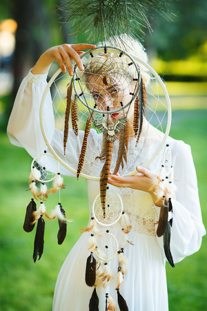 Outdoor portrait of a beautiful topmodel girl with dream catcher vintage and retro tone, soft focus. Full red lips.の写真素材