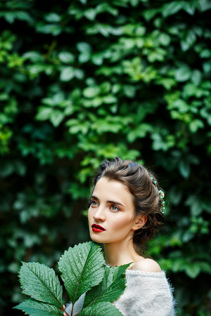 Portreit of young girl with grape leaf in her handの写真素材