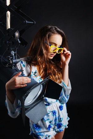 Assistant operator girl with studio lightの写真素材