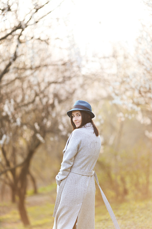 Girl in a green hat in a blooming gardenの写真素材