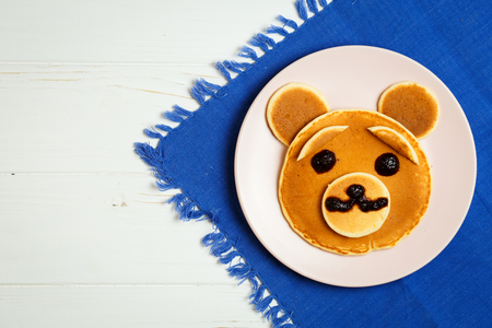 Baby pancakes in a pink plate on a blue towel with space for textの写真素材