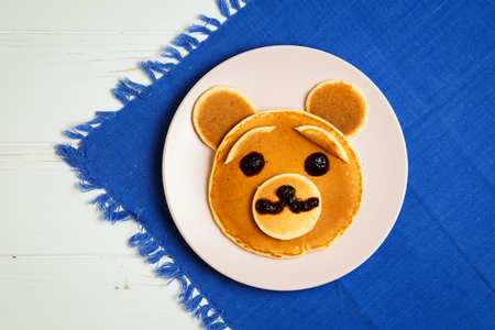 Baby pancakes in a pink plate on a blue towel with space for textの写真素材