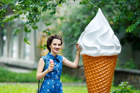 Bright picture of pretty woman eating melted ice-cream on the streetの写真素材