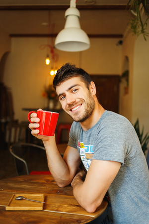 Man holding red cup of coffee in handの写真素材