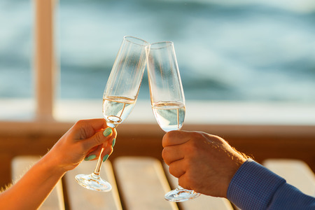 Happy couple drinks champagne on a yachtの写真素材