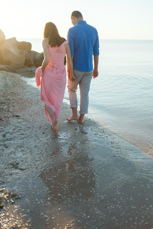 Close up of loving couple holding hands on a beach near the seaの写真素材