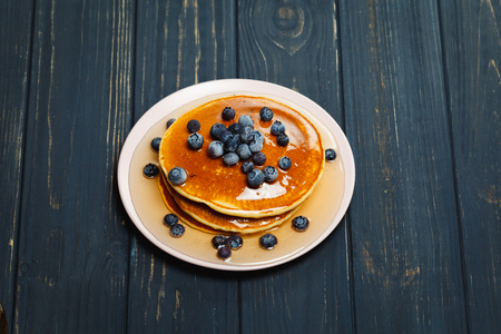 Pancakes with honey and blueberries on wooden tableの写真素材