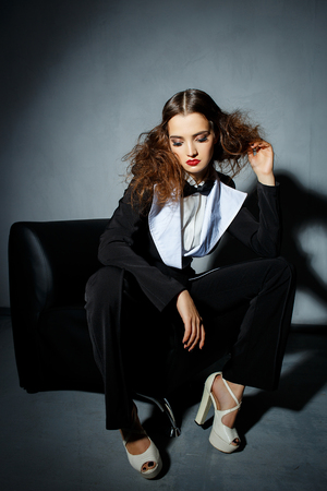 Brunette model posing on couch in the studioの写真素材