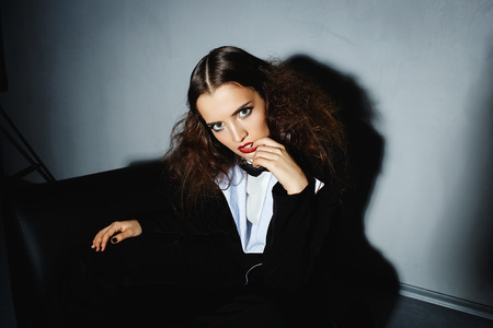 Brunette model posing on couch in the studioの写真素材