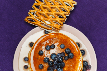Breakfast for children with pancakes, honey and blueberriesの写真素材