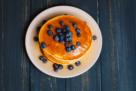 Tasty pancakes with blueberries and honey on tableの写真素材