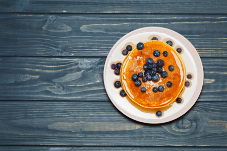 Tasty pancakes with blueberries and honey on tableの写真素材