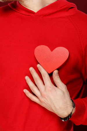 Youngman with a red heart in his hands on Valentine dayの写真素材