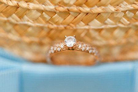 Golden engagement ring with diamonds lying on the canotier hatの写真素材