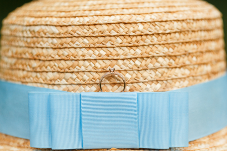 Golden engagement ring with diamonds lying on the canotier hatの写真素材