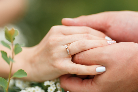Man giving an engagement ring to his girlfriend In flower garden, holding her hand. Boyfriend Surprised Her Girlfriend With Engagement Ring in flower garden.の写真素材