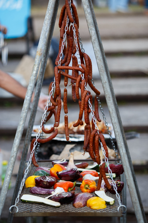Grilled vegetables and hunting sausages cooking on street. With copy spaceの写真素材