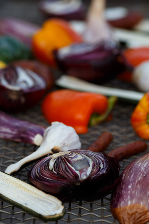 Grilled vegetables on a baking sheet, orange pepper and yellow pepper, zucchini, eggplant, hunting sausages, onion and garlic. Street food.の写真素材