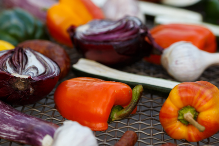 Grilled vegetables on a baking sheet, orange pepper and yellow pepper, zucchini, eggplant, hunting sausages, onion and garlic. Street food.の写真素材