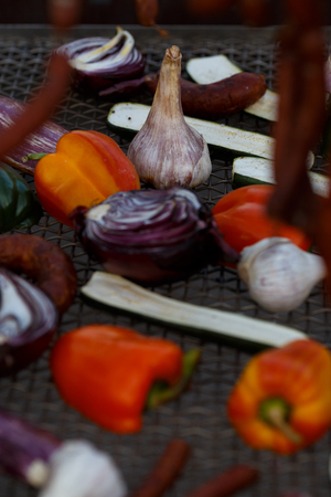 Grilled vegetables on a baking sheet, orange pepper and yellow pepper, zucchini, eggplant, hunting sausages, onion and garlic. Street food.の写真素材