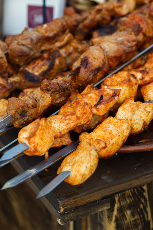 Grilled kebab cooking on metal skewer. Roasted meat cooked at barbecue. BBQ fresh beef meat chop slices. Traditional eastern dish, shish kebab. Grill on charcoal and flame, picnic, street foodの写真素材