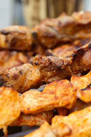 Grilled kebab cooking on metal skewer. Roasted meat cooked at barbecue. BBQ fresh beef meat chop slices. Traditional eastern dish, shish kebab. Grill on charcoal and flame, picnic, street foodの写真素材