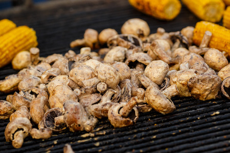 Champignon white mushrooms grilled on grill or BBQ steam. Cooking mushrooms on the grill. Portobello mushrooms marinated and grilling. Grilled vegetables on a grill close up.の写真素材
